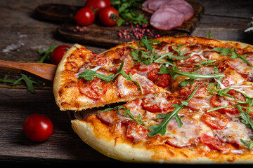 Appetizing pizza with ham on a wooden background