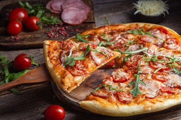 Appetizing pizza with ham on a wooden background