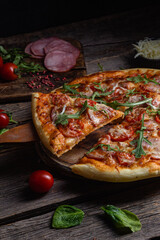 Appetizing pizza with ham on a wooden background