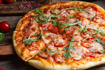 Appetizing pizza with ham on a wooden background