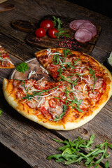 Appetizing pizza with ham on a wooden background