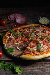 Appetizing pizza with ham on a wooden background