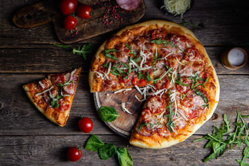 Appetizing pizza with ham on a wooden background