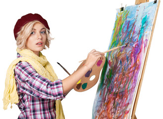 Young beautiful woman with palette and holding paintbrush while standing isolated against white...