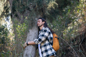 Long hair man in green forest