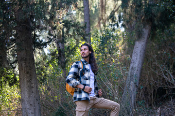 Long hair man in green forest