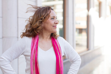 middle age woman looking happy, cheerful and confident, smiling proudly and looking to side with both hands on hips