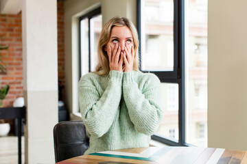 young pretty woman feeling shocked and scared, looking bored with hands on cheeks