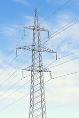 Metal pole of an overhead power line vertically against the sky.