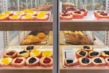 Assorted various types of brioches  arranged on tray selling at bakery shop.