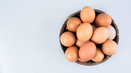 Whole chicken eggs in basket on white background, top view, copy space