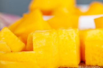 Sweet ripe orange pumpkin is sliced on the table