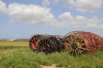 Cable drums with fiber optic cable.Technologies poly underground conduit in a green field, on a...