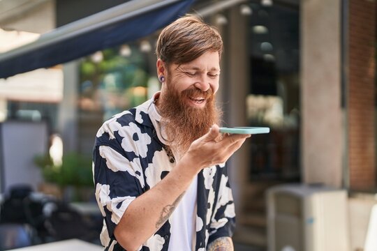 Young redhead man smiling confident talking on the smartphone at street