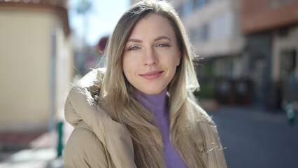 Young blonde woman smiling confident standing at street
