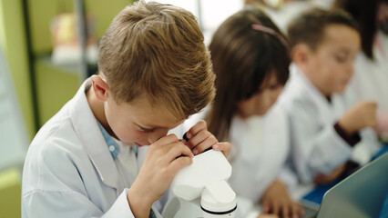 Obraz premium Group of kids students using microscope at laboratory classroom