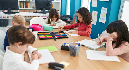 Group of kids students sitting on table studying at classroom