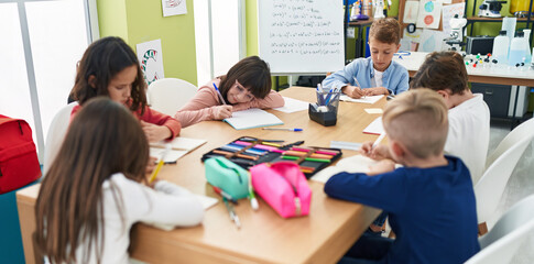 Group of kids students sitting on table studying at classroom