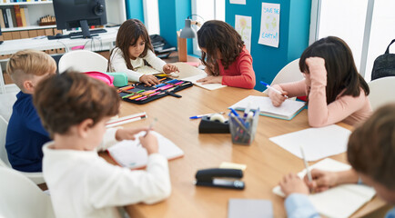 Group of kids students sitting on table studying at classroom