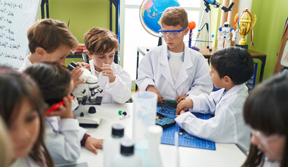 Fototapeta premium Group of kids students talking on smartphone repairing gadget at laboratory classroom