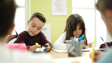 Group of kids students sitting on table studying at classroom