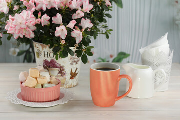 cup of coffee with marshmallow on white wooden table