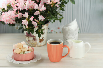 cup of coffee with marshmallow on white wooden table