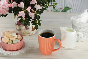 cup of coffee with marshmallow on white wooden table