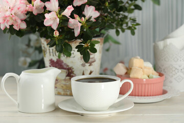cup of coffee with marshmallow on white wooden table