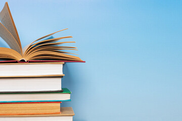 Stack of books in the colored cover lay on blue backround. Education learning concept