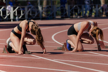 two female athletes low start running 100 meters in track stadium, summer athletics championship