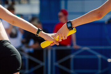 hand women passing baton running relay race in summer athletics championship