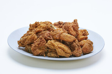 Pile of Crispy Fried Chicken with flour coating  on a plate, isolated white background