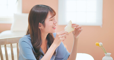asian woman biting toast happily