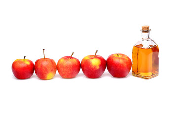 Natural apple cider vinegar. On an isolated white background. In a small bottle and surrounded by apples.
