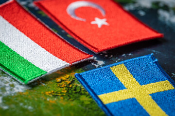 The flags of Turkey and Hungary in front of the symbol of Sweden. The concept of mutual relations...