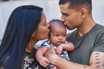 Hispanic family hugging each other and kissing at street