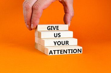 Give us your attention symbol. Concept words Give us your attention on wooden block. Beautiful orange table orange background. Motivational business give us your attention concept. Copy space.