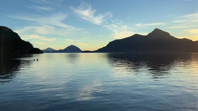 Background for travel travel agency Porteau Cove Provincial Park Sunset city immersed in water reflecting in the Pacific Ocean creating mirror image The camera moves slowly capturing beauty of nature