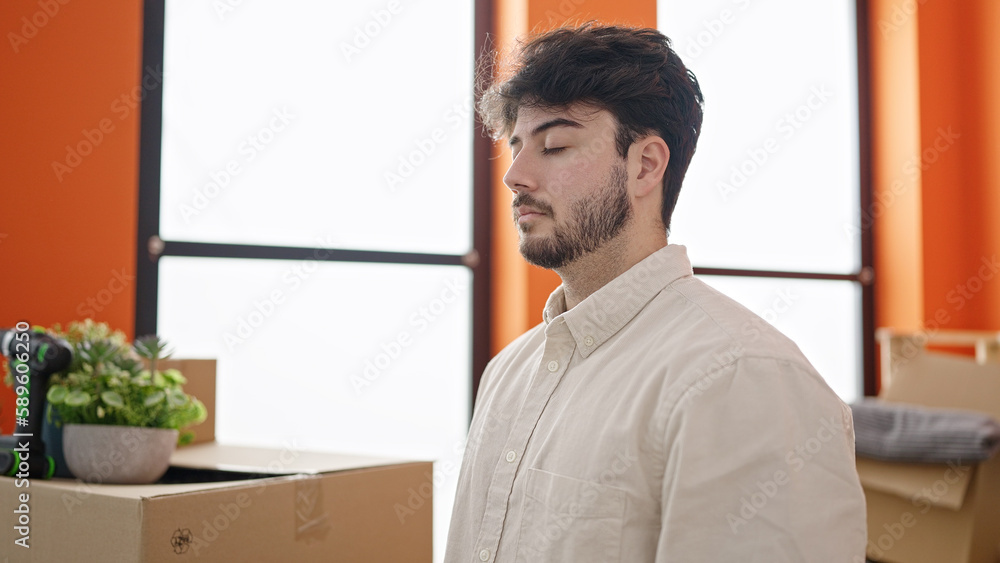 Sticker young hispanic man breathing with closed eyes at new home