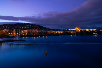 Fototapeta na wymiar Dreamy night view to the Prague Castle from Vltava river with magical sky and lights from streets on the evening in the Old Town of amazing historic city Prague, Czech Republic, Europe.