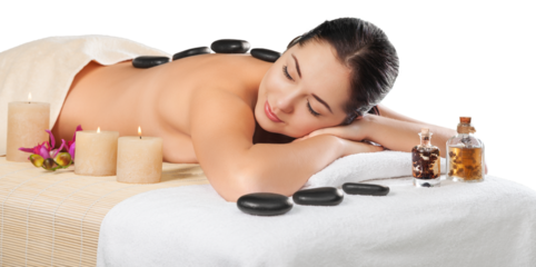Beautiful young woman receiving hot stone massage at salon spa