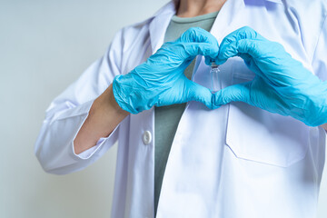 Doctor, infectionist or scientist wearing medical glove is showing coronavirus vaccine with heart sign for against coronavirus, covid-19 on white background and copy space. Covid-19 vaccine concept.