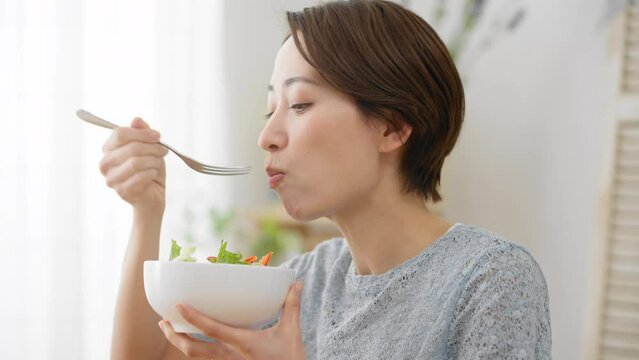 サラダを食べる若い女性　飲食イメージ