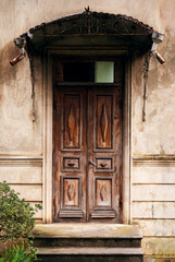 Old wooden door with a metal canopy of an old house in Georgia.