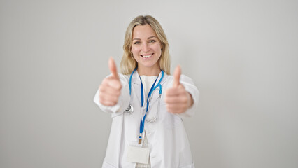 Young blonde woman doctor doing thumbs up over isolated white background