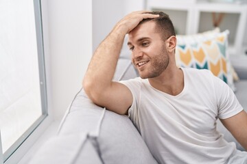 Young caucasian man smiling confident sitting on sofa at home