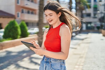 Young caucasian woman smiling confident using touchpad at park