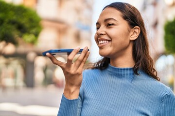 Young african american woman smiling confident talking on the smartphone at street