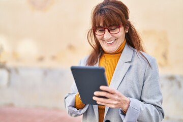 Middle age woman business executive using touchpad at street